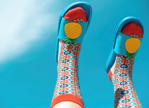 Fußpflege in meinem Kosmetikstudio - lustige Badeschuhe und Socken an Füßen, die Richtung Himmel zeigen